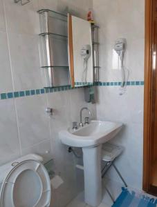 a bathroom with a sink and a toilet at Flat encantador localizado no melhor de Serra Negra - SP in Serra Negra