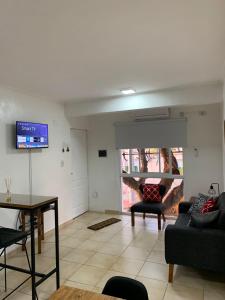 a living room with a couch and a tv at Departamentos Rodrigo in Posadas