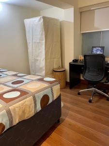Habitación con cama, escritorio y silla. en Like home, en Lima