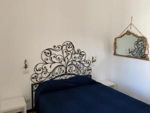 sypialnia z niebieskim łóżkiem i lustrem w obiekcie FraLePorte Vintage Apartment w mieście Palermo