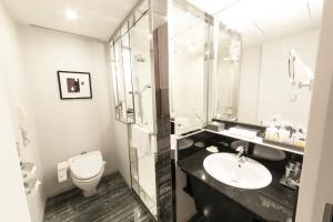
a bathroom with a toilet, sink and mirror at ANA Crowne Plaza Osaka, an IHG Hotel in Osaka
