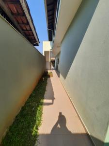 een schaduw van een persoon aan de zijkant van een gebouw bij Lindo Apto Ubatuba a 300 metros Praia Sape in Ubatuba