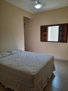een slaapkamer met een bed en een raam bij Lindo Apto Ubatuba a 300 metros Praia Sape in Ubatuba