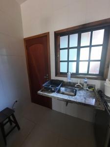 een keuken met een spoelbak en een raam bij Lindo Apto Ubatuba a 300 metros Praia Sape in Ubatuba +17 foto's