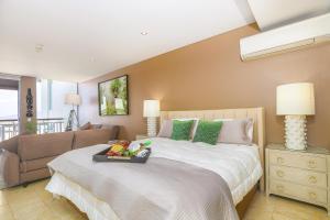 una camera con un grande letto e un divano di Santai Sands - with Sea and Mountain Glimpses! a Casuarina