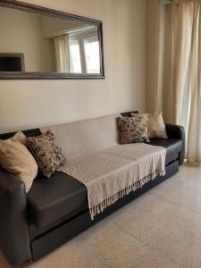 un sofá negro con almohadas en una habitación en Departamento 2 ambientes Excelente ubicacion en Mar del Plata