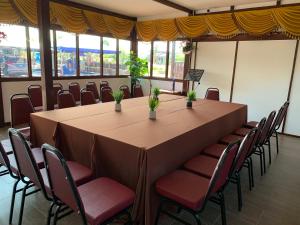 a large table and chairs in a room with windows at D'Razna Chalet Pantai Seberang Takir in Kuala Terengganu