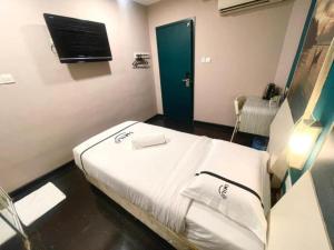 una camera ospedaliera con un letto e una porta verde di Smile Hotel Chow Kit PWTC a Kuala Lumpur