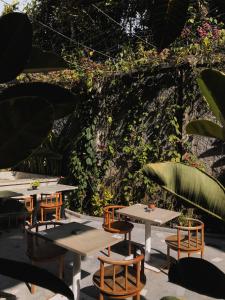 a group of tables and chairs with plants at ARTOTEL Haniman Ubud in Ubud