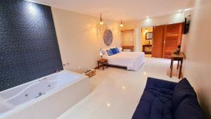 1 dormitorio y baño grande con bañera. en Pousada Paraíso Gaia en Praia do Rosa