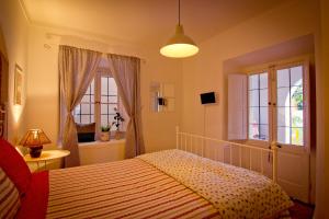 a bedroom with a bed and two windows at Cascais Boutique Hostel in Cascais