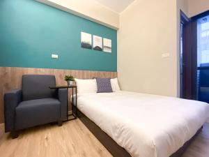 a bedroom with a bed and a chair at 想想旅居 Allegro Hostel in Taichung