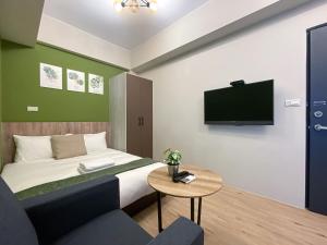 a bedroom with a bed with a tv and a table at 汨嵐旅居 Allegro Hostel in Taichung