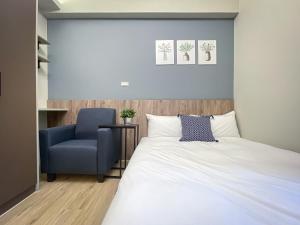 a bedroom with a bed and a blue chair at 想想旅居 Allegro Hostel in Taichung