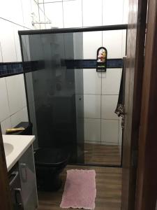 a bathroom with a shower with a toilet and a sink at Casa 3 quartos in Pontal do Paraná