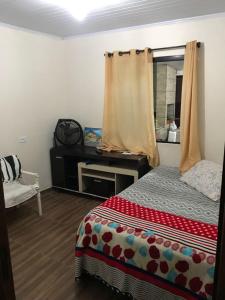 a bedroom with a bed and a window and a mirror at Casa 3 quartos in Pontal do Paraná