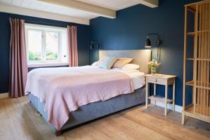 a blue bedroom with a bed and a window at Mein Nordstern in Humptrup