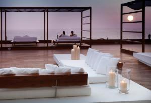 two people sitting in beds in a room with candles at H10 Gran Tinerfe - Adults Only in Adeje