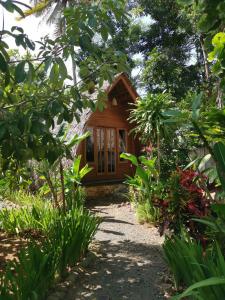 a house in the middle of a garden at Coconut Tree Cottages in Batukaras