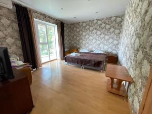 a bedroom with a bed and a table in it at Dom Tourista Guest House in Millerovo