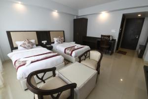 a hotel room with two beds and a couch and chairs at Hotel Star Bodh Gaya in Bodh Gaya