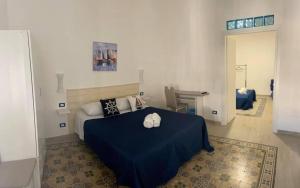 sypialnia z niebieskim łóżkiem i 2 białymi ręcznikami w obiekcie La casetta di Mavi w mieście Palermo