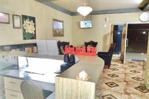 a living room with a table and chairs in a room at Hotel Indah Grogot Syariah Mitra RedDoorz in Tana Paser