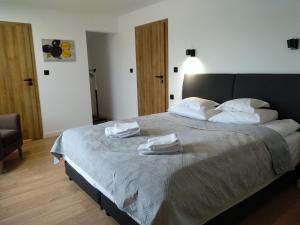 a bedroom with a large bed with two towels on it at FraToLe in Nielisz