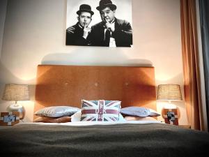 a bedroom with a bed with a portrait of two men at Hotel Am Volksgarten in Düsseldorf