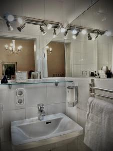 a white bathroom with a sink and a mirror at Hotel Am Volksgarten in Düsseldorf