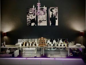 a room with a table with glasses and pictures on the wall at Hotel Am Volksgarten in Düsseldorf