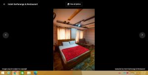 um quarto com uma cama com uma colcha vermelha em Hotel Sarfaranga & Restaurant em Ranga