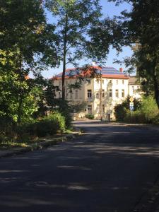 een groot wit huis aan de kant van een weg bij Parkhotel Schnorr in Lutherstadt Eisleben