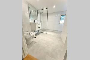 a bathroom with a toilet and a glass shower at Eget hus med bra läge och toppstandard in Linköping