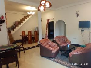a living room with two couches and a table at Arusha Guest House in Negombo