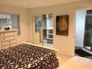 ein Schlafzimmer mit einem Bett und einem begehbaren Kleiderschrank in der Unterkunft Beautiful Modern Suite in North Vancouver