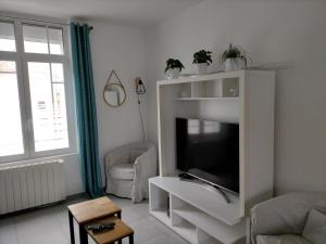 ein Wohnzimmer mit einem TV in einem weißen Unterhaltungszentrum in der Unterkunft Gîte Cœur d'Opale, seul hébergement 4 étoiles sur Étaples in Étaples