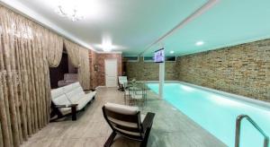 a large swimming pool in a room with a brick wall at Rest House in Volgograd