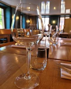 a wine glass sitting on top of a wooden table at Le Valtrivin in Lapoutroie