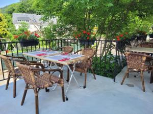 una mesa y sillas en un patio con flores en Le Valtrivin en Lapoutroie