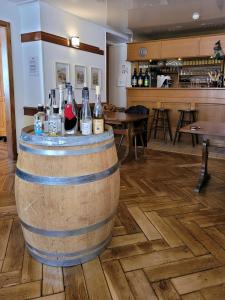 a large wooden barrel with bottles of wine on it at Le Valtrivin in Lapoutroie