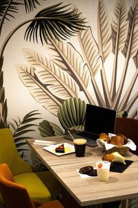 a wooden table with a laptop on top of it at Appart Hôtel La vie est belle in Lalinde