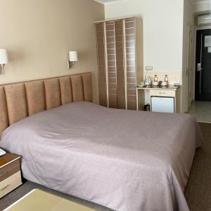 a bedroom with a large bed and a kitchen at Garni Hotel Sibiria in Perm