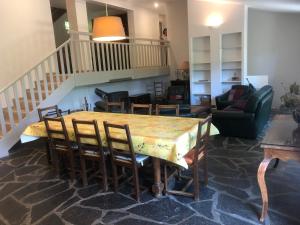 une salle à manger avec une table, des chaises et un escalier dans l'établissement L'Oursiere, à Bédouès