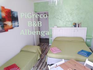 een slaapkamer met 2 bedden en een tafel bij PiGreco in Albenga