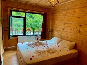 Un dormitorio con una cama con corazones rojos. en TUVA VİLLA Bungalov, en Çamlıhemşin