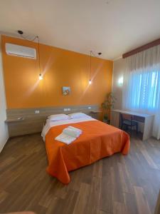 een slaapkamer met een bed met een oranje deken bij All’Anoneto B&B in Catona