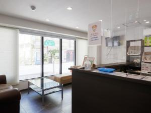 a kitchen with a counter with a table and a window at BiBi Hotel 国際通り店 in Naha