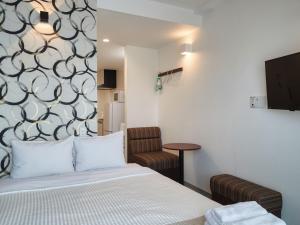 a small room with a bed and a chair at BiBi Hotel Kokusaidori in Naha