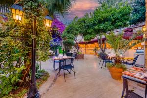 een patio met een tafel, stoelen en bomen bij Dogan Hotel in Antalya